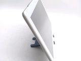 a tablet computer sitting on a stand on a white surface