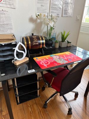 a black desk with a red chair in front of it
