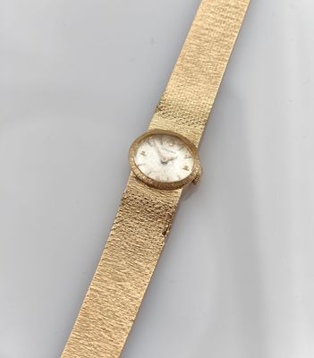 a close up of a gold watch on a white surface