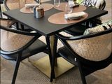 une table avec quatre chaises et une table sur laquelle sont disposés des couverts