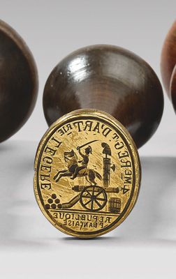 trois boules en bois sur lesquelles repose une pièce d'or, disposées les unes à côté des autres