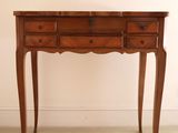 a small wooden table with two drawers on it