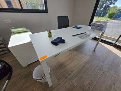 a white desk with a black chair in front of a window