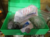 une boîte verte remplie d'objets divers, posée sur une table