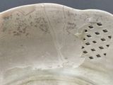a white bowl with a hole in the middle of it