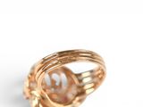 an image of a gold ring with a pearl in it
