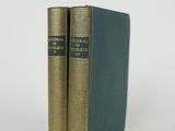 two books sitting on top of each other on a white surface