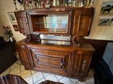 une armoire en bois avec une porte vitrée et une table avec deux chaises