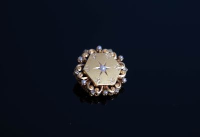 une bague en or ornée d'une étoile, posée sur un fond noir