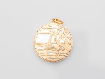 a close up of a gold pendant with a boat on it