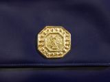 navy blue purse with a gold medallion on the front of it