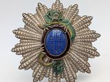 a close up of a broochle with a blue stone in it