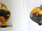 two vases on display in a book on a table