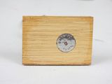 a small wooden clock on a table with a white background