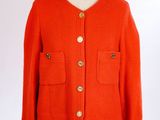une veste orange sur un mannequin, avec des boutons