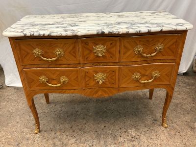 a marble top chest of drawers with gold handles
