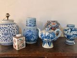Plusieurs vases bleus et blancs sont posés sur une table en bois.