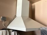 une photo d'une cuisine avec une cuisinière et une hotte murale