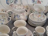 many cups and saucers sitting on a table