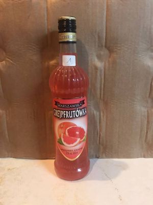 a bottle of grapefruit on the counter next to a pillow