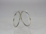 pair of silver hoop earrings on clear acrylic stand