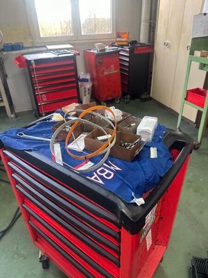 un chariot à outils rouge contenant des outils, dans un garage