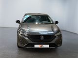 the front of a grey car in a showroom with a white wall