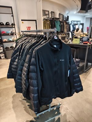 des vêtements exposés dans un magasin de vêtements, avec un portemanteau rempli de vestes