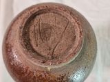 un gros plan d'un vase marron posé sur une surface blanche