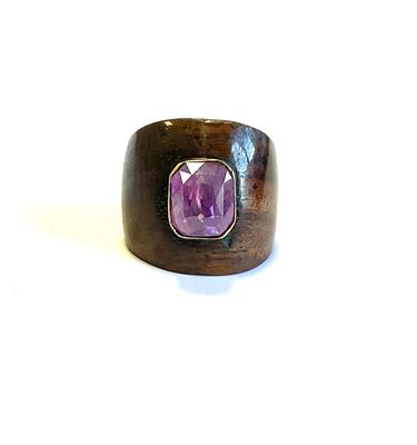 une image représentant une bague en bois ornée d'une pierre violette au centre