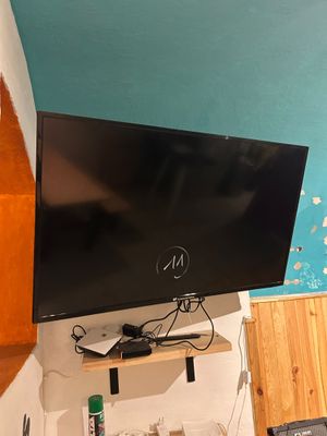 un téléviseur à écran plat fixé au mur d'une pièce
