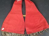a red scarf with fringes on a black surface