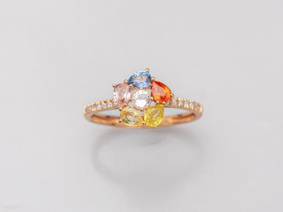 une bague en or jaune sertie de trois pierres de couleurs différentes