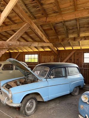 deux vieilles voitures garées dans un garage