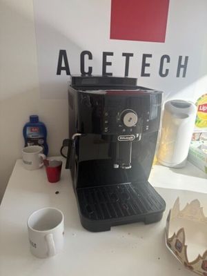 a coffee maker sitting on a table next to a cup of coffee