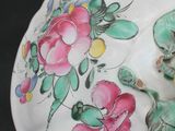 a white vase with flowers painted on it on a table