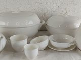 a white table with a lot of white dishes and cups