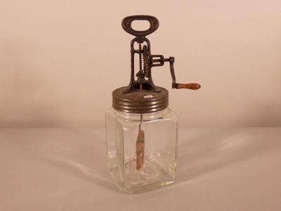 a glass jar with a corkscrew on top of it
