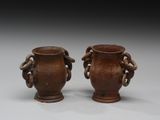 deux vases marron posés l'un à côté de l'autre sur une table