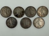 six different types of silver coins on a white surface