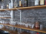Des bouteilles et des verres sont alignés sur une étagère dans un bar