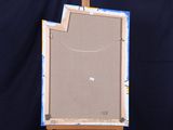 a painting on a easel with a piece of paper taped around it