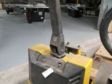 a forklift sitting in a warehouse with a wheel on it