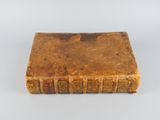 an old book sitting on top of a white surface