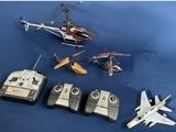 four remote controls and a remote control helicopter on a blue surface