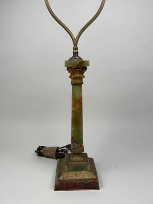 une lampe à l'ancienne avec un pied en métal et un abat-jour en verre vert