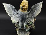 une statue représentant un oiseau perché sur une branche