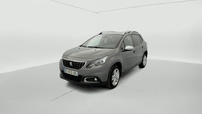 Une voiture grise est garée dans une pièce blanche au sol blanc.