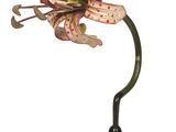 flower on a black stand with a green stem and a pink flower