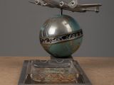 a metal sculpture of a plane on top of a globe